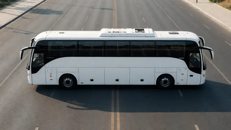 Side view of a large white passenger bus on an empty paved road.