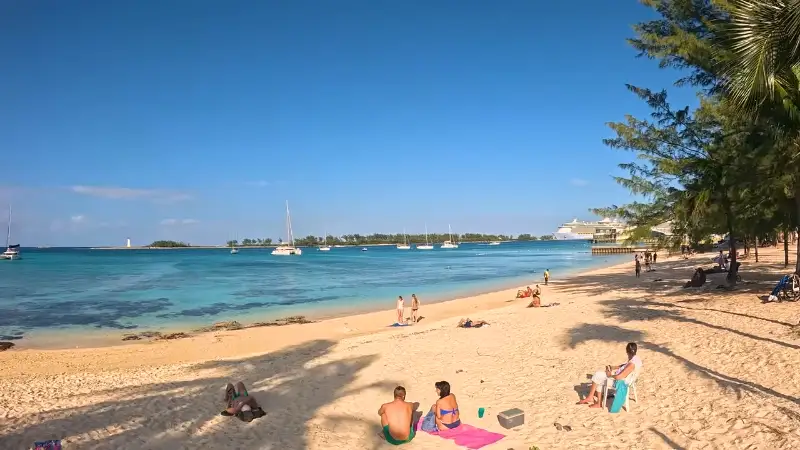 People enjoying water sports on a sunny Nassau beach with inflatable rafts