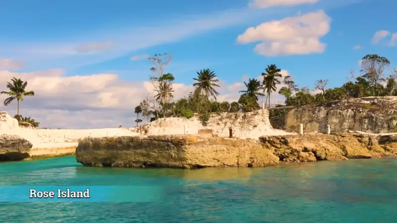 Rocky coastline of Rose Island with turquoise water and palm trees